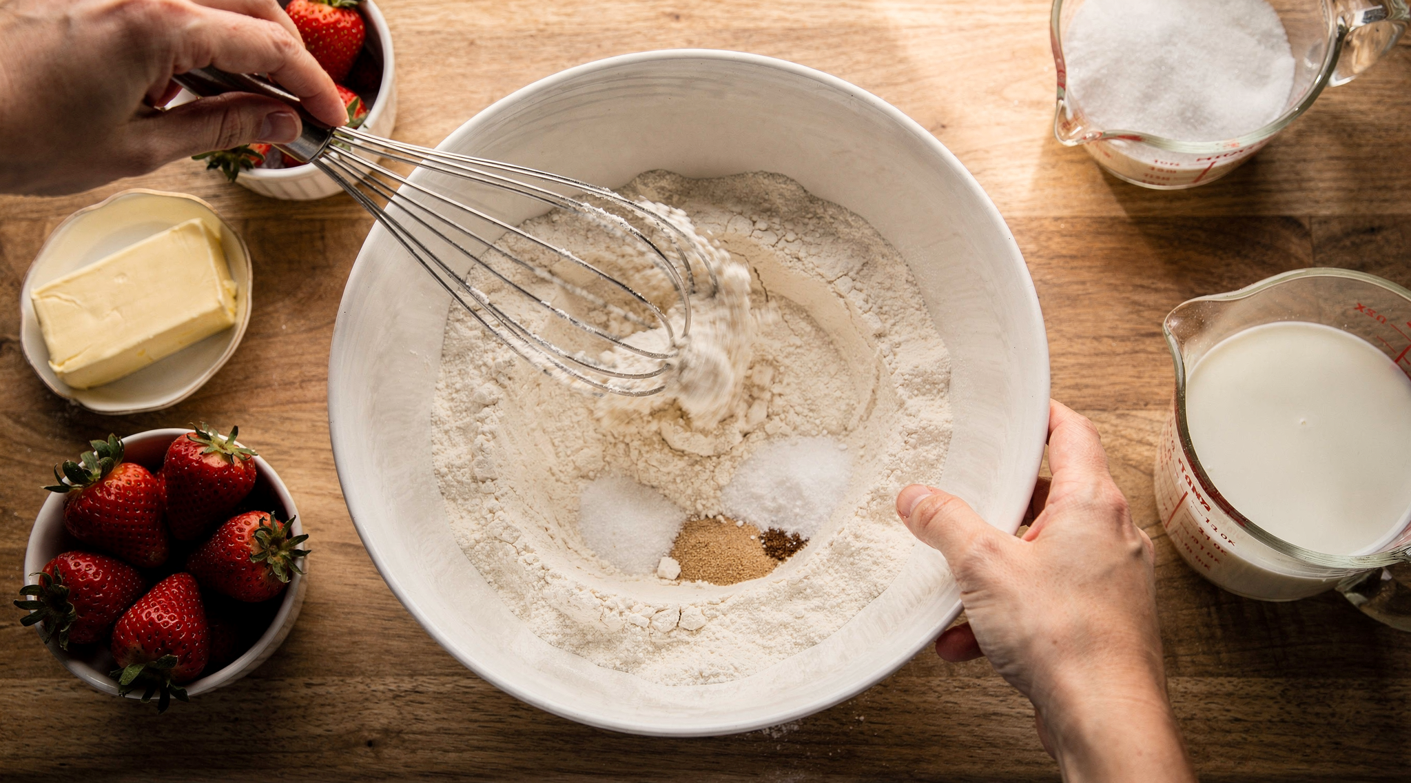Whisking dry ingredients in a ceramic bowl for strawberry shortcake
